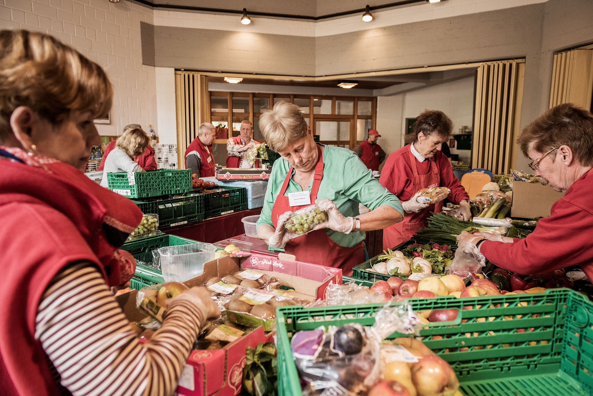 Bei der Tafel ist immer viel zu tun. Mehrere Frauen teilen Essen an Kunden aus